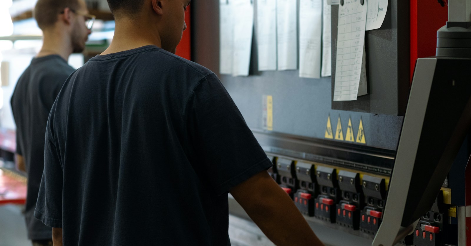 Machine operator at a press brake on a shop floor, where leadership development for manufacturing companies begins