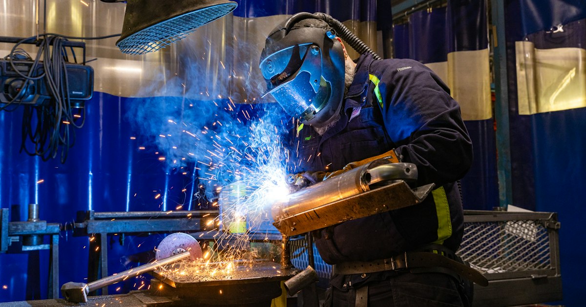 Welder in protective gear at an Oshawa plant, a skilled trade role at the centre of employee turnover Oshawa manufacturing leaders face