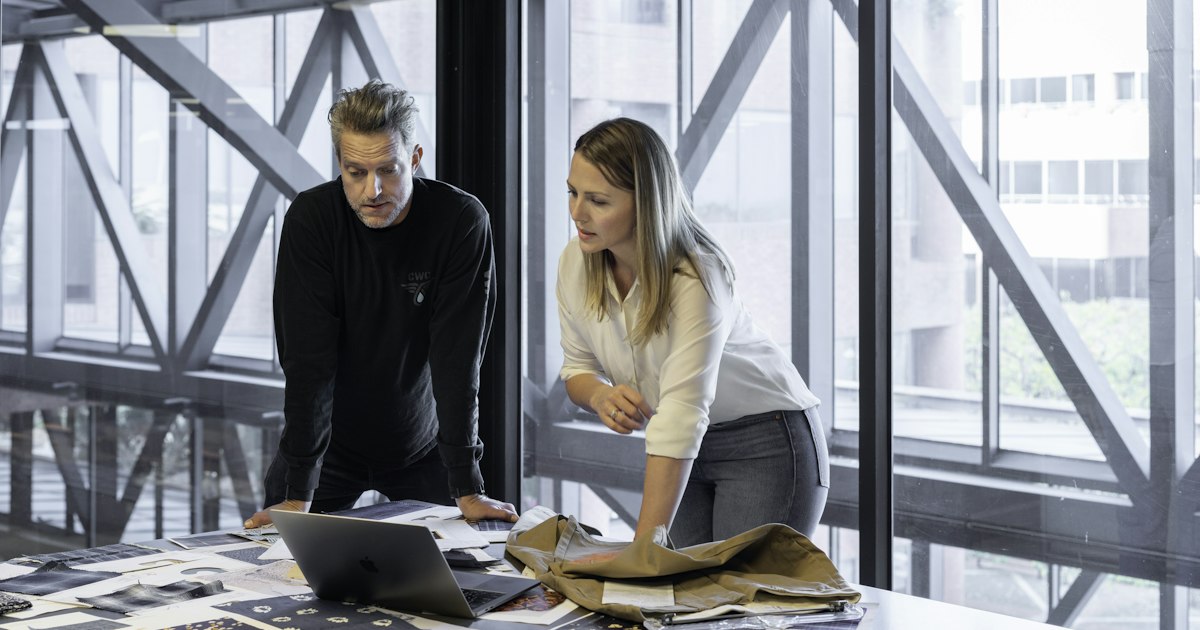 Two business leaders reviewing plans at a desk to increase company value through leadership